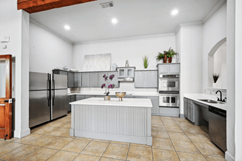 a large kitchen with stainless steel appliances and a white island